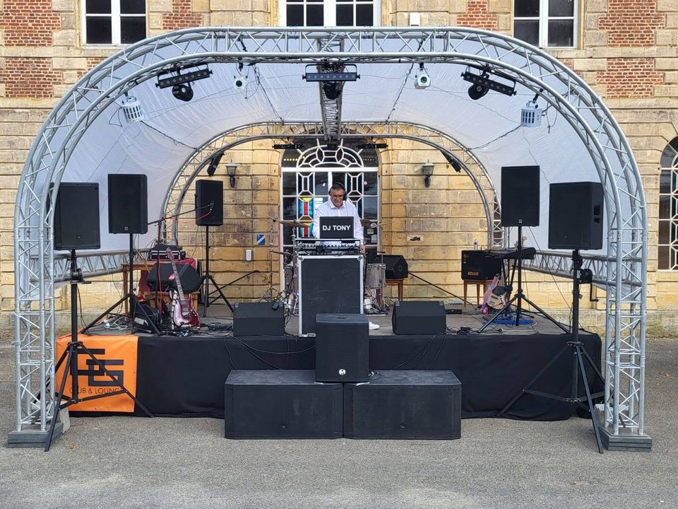 La scène en plein air sous une arche de projecteurs, avec le stand DJ Tony